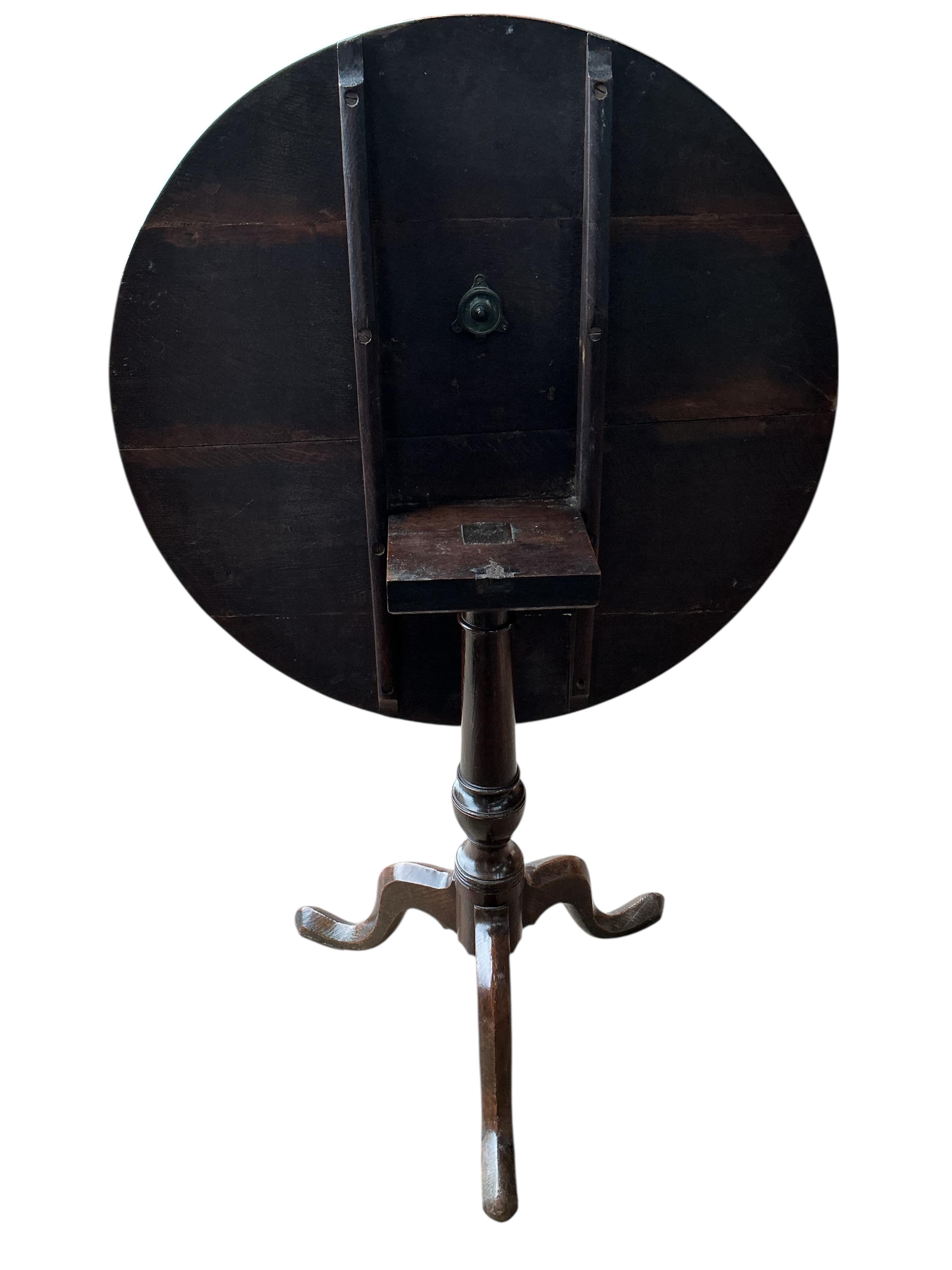 An early 19th century circular oak tilt top tripod tea table, diameter 76cm, height 72cm